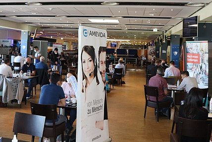 Das Bild zeigt die VfL-Lounge im Ruhrstadion während des Job-Speed-Datings. Der Raum ist voller Menschen, die Tische für die Vorstellungsgespräche sind besetzt.